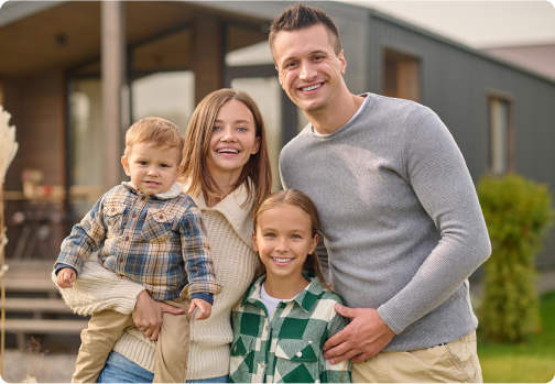 Happy family of four smiling outdoors together