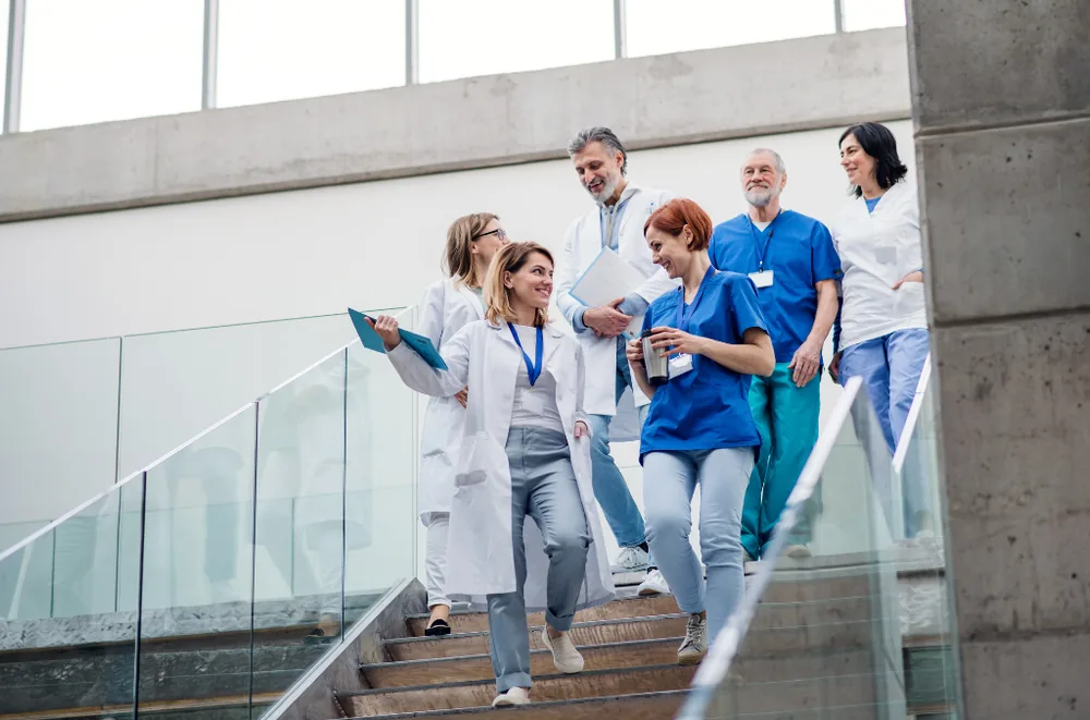A team of healthcare providers walking together outside a medical building